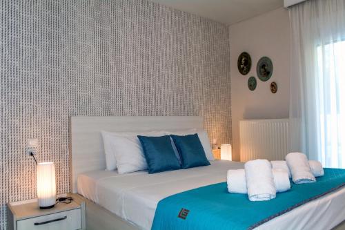 a bedroom with a bed with blue and white pillows at Chris Rea Villa in Skiathos Town