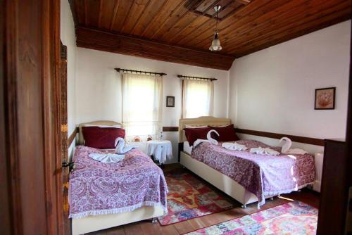 a bedroom with two beds and two windows at Badeli Konak Safranbolu in Safranbolu