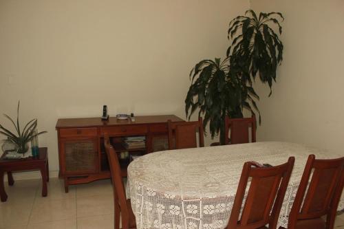 a dining room with a table and a desk and a plant at Habitaciòn Cambulos 3 in Cali