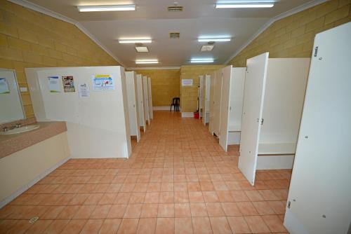 a row of white toilets in a small room at Riverbend Caravan Park Renmark in Renmark