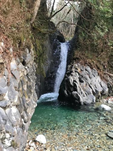 a waterfall on the side of a rocky river at Takayama Ninja House in Takayama