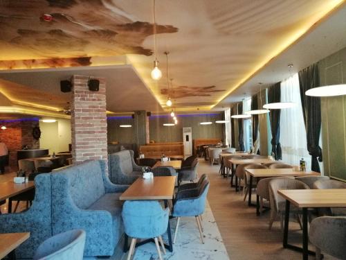 a restaurant with blue chairs and tables and tables and chairs at Allure Beach Resort Aparthotel in Primorsko