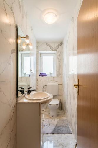a bathroom with a sink and a toilet at Azzuro in Kaštela