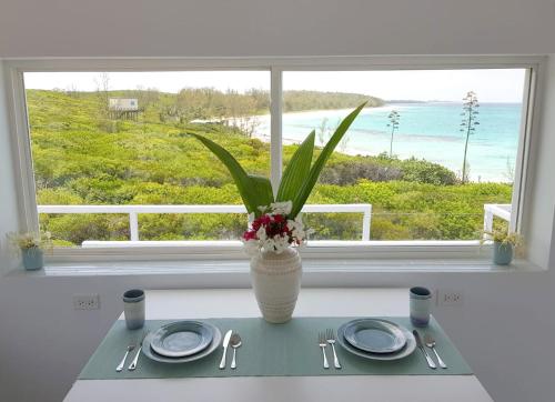 a table with plates and a vase with flowers in a window at Mika's Resort in Colebrooke Dale