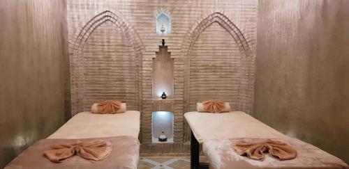 two beds in a room with arches on the wall at Riad Dar Haven in Tamraght Ou Fella