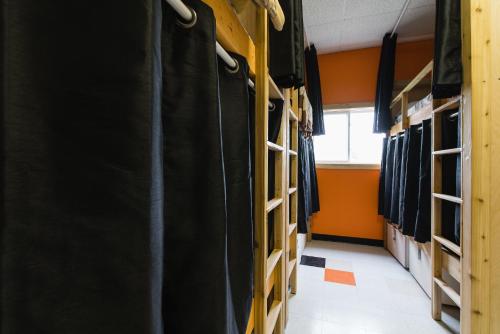 a room filled with racks of clothes at Out East Hostels - Rocky Harbour in Rocky Harbour