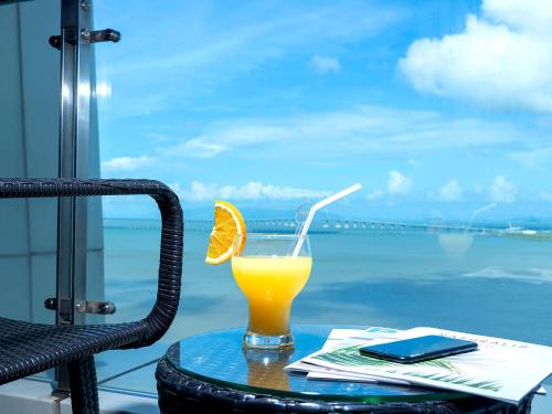 a glass of orange juice sitting on top of a table at Similan Hotel Zhuhai-Gongbei Port in Zhuhai