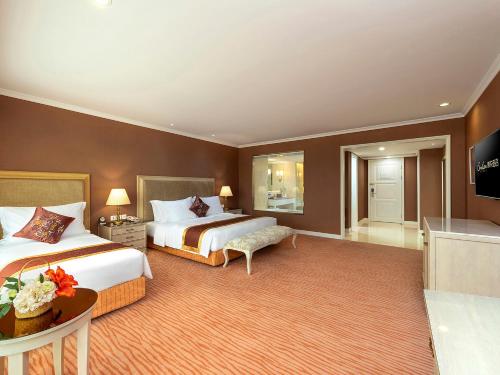 a hotel room with two beds and a television at Similan Hotel Zhuhai-Gongbei Port in Zhuhai