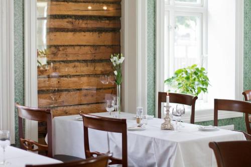 a dining room with a table with white table cloth at Hotel Kong Carl - Unike Hoteller in Sandefjord