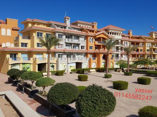 a large building with a courtyard with trees and bushes at Chalets in Porto Sharm - Families Only AN in Sharm El Sheikh