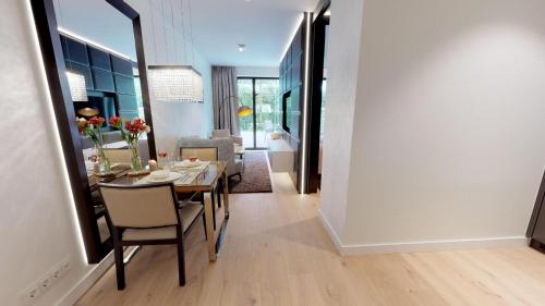 - une salle à manger et un salon avec une table et des chaises dans l'établissement White Pearl Apartment 0.14, à Timmendorfer Strand