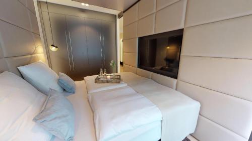 Cette chambre comprend 2 lits et une télévision. dans l'établissement White Pearl Apartment 0.14, à Timmendorfer Strand