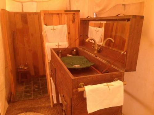 a wooden bathroom with a sink and a mirror at Maroc Sahara Luxury Camp & Tours in Foum Zguid