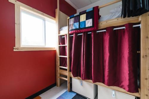 a room with bunk beds and a window at Out East Hostels - Rocky Harbour in Rocky Harbour