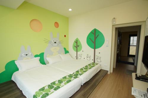 a bedroom with a bed with rabbits on the wall at 胖蝸牛親子民宿 in Tainan