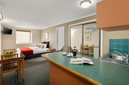 
a hotel room with two beds and a table at Quest Waterfront in Hobart
