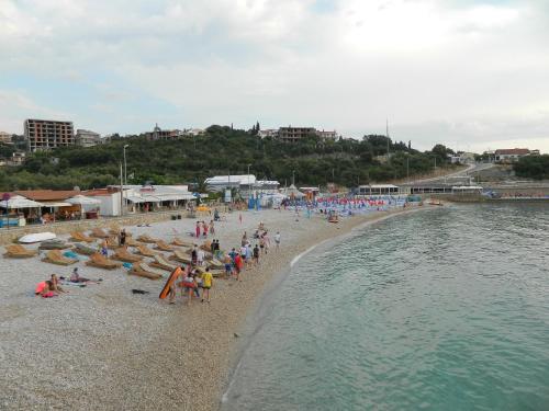 a group of people on a beach near the water at President Bungalows and Apartments in Utjeha