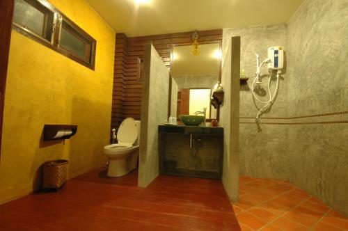 a bathroom with a toilet and a sink and a mirror at Phunacome Resort in Dan Sai