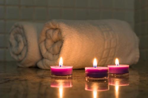 three candles sitting on a table with a towel at Boulevard Residencial in Salvador