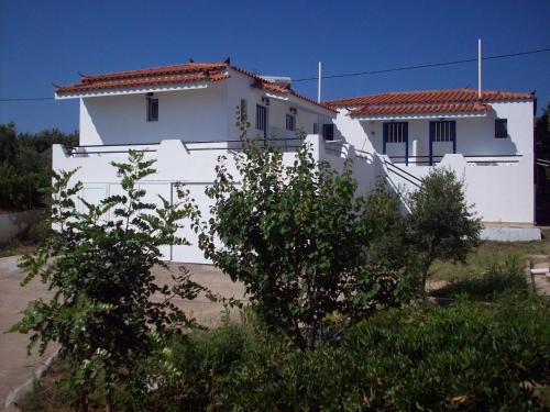 a white house with trees in front of it at The Captain in Elafonisos