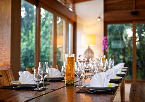 een lange houten tafel met glazen en servetten erop bij Baan Hinta in Lamai