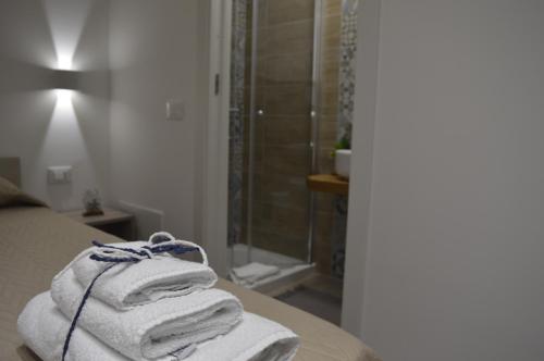 einen Haufen Handtücher auf einem Bett im Bad in der Unterkunft Casa Catalano in San Vito lo Capo