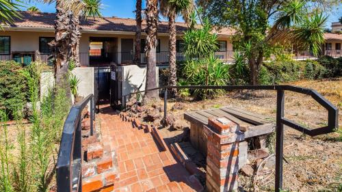 a house with palm trees and a brick staircase at Best Western Sandman Hotel in Sacramento