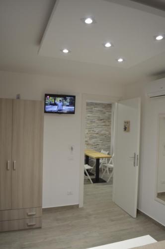 Habitación con TV en la pared y mesa. en Casa Catalano, en San Vito lo Capo