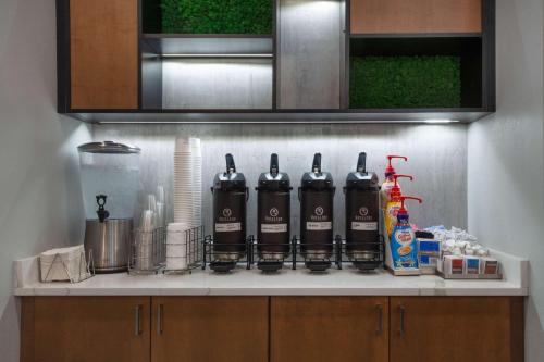 a kitchen counter with four bottles of wine on it at La Quinta by Wyndham Ft. Myers - Sanibel Gateway in Fort Myers