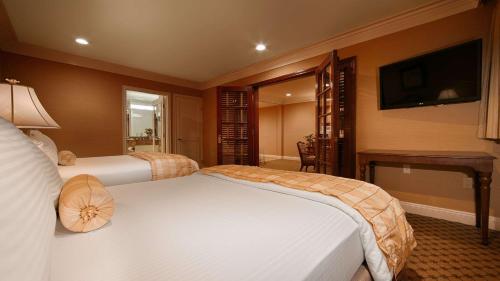a hotel room with two beds and a flat screen tv at Best Western Plus Sunset Plaza Hotel in Los Angeles