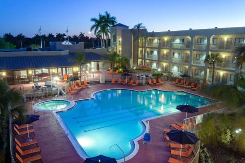 uma piscina em frente a um hotel à noite em La Quinta by Wyndham Ft. Myers - Sanibel Gateway em Fort Myers