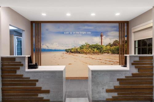 a room with a picture of a beach with a lighthouse at La Quinta by Wyndham Ft. Myers - Sanibel Gateway in Fort Myers