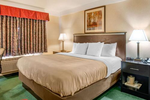 a large bed in a hotel room with two lamps at Bend Quality Inn in Bend