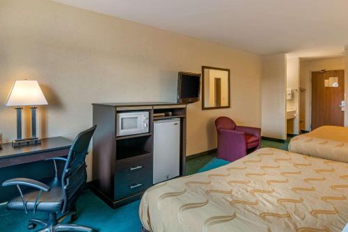 a hotel room with a bed and a desk with a computer at Quality Inn Bend North in Bend