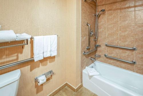 y baño con bañera, aseo y toallas. en The Grand Hotel, Ascend Hotel Collection, en Frisco