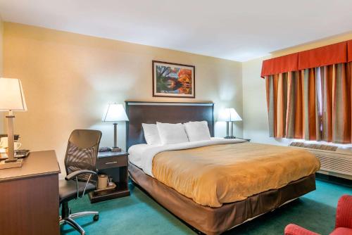 a hotel room with a bed and a desk at Quality Inn Bend North in Bend
