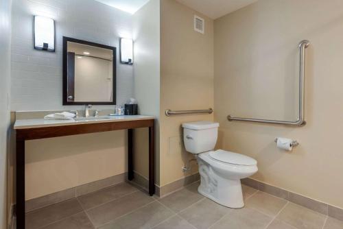 a bathroom with a toilet and a sink and a mirror at Comfort Inn & Suites in Napanee