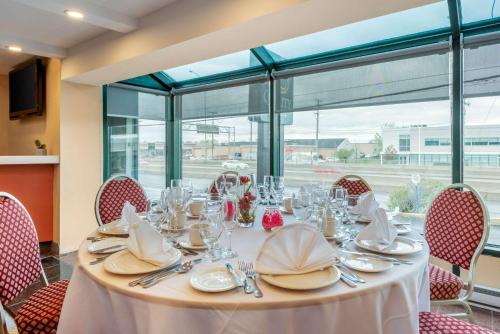 a table with plates and napkins on top at Quality Hotel Dorval Aeroport in Dorval