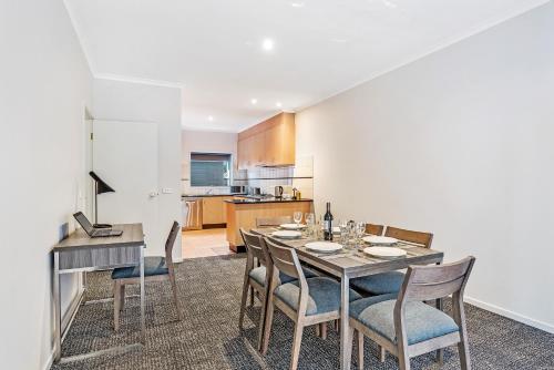 a kitchen and dining room with a table and chairs at Quest Brighton on the Bay in Melbourne
