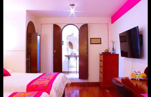 a bedroom with a bed and a dresser and a tv at Calle Berlin Boutique in Mexico City