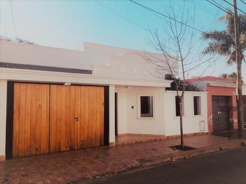 a white house with wooden doors on a street at Alberta B&B in La Rioja