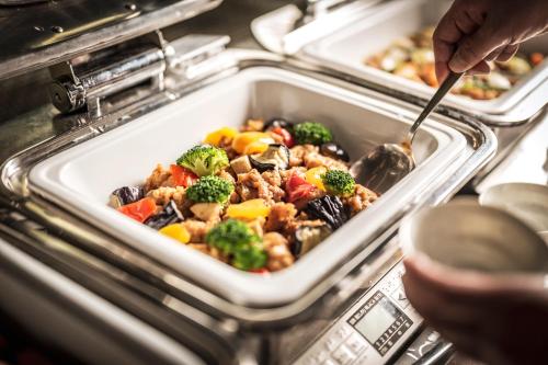 a person is serving a meal in a tray of food at Hotel Kuu Kyoto in Kyoto