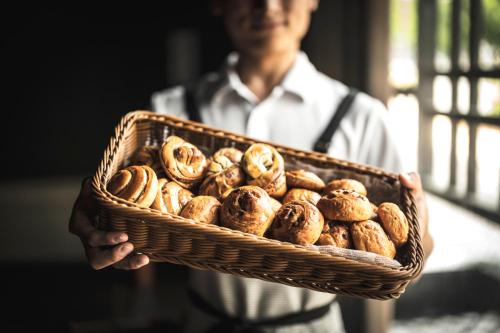 a man is holding a basket of doughnuts at Hotel Kuu Kyoto in Kyoto