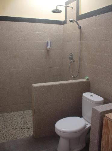 a bathroom with a toilet and a tub and a shower at Dayuh Homestay in Amed