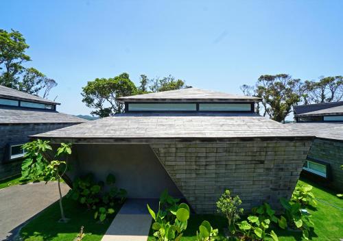 a brick house with a pitched roof at Miru Amami in Tatsugo