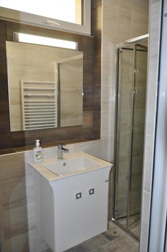 a bathroom with a white sink and a mirror at Къща за гости Ирис in Kyustendil