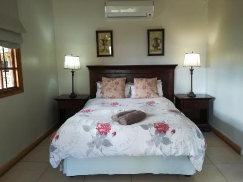 a bedroom with a large bed with two lamps at Avoca River Cabins in Addo