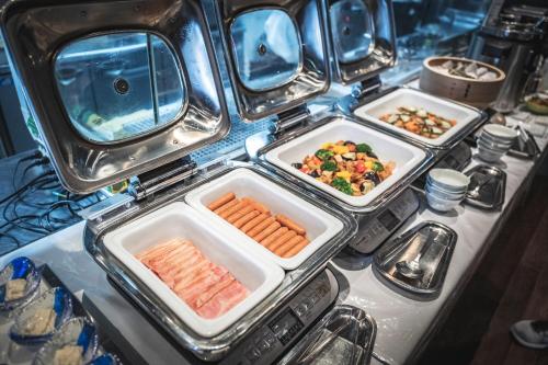 two trays of food with carrots and vegetables in them at Hotel Kuu Kyoto in Kyoto