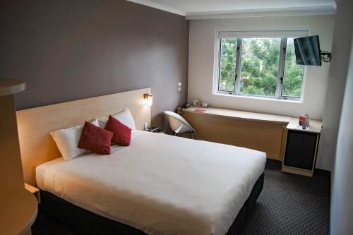 una camera d'albergo con letto e finestra di ibis Sydney Olympic Park a Sydney