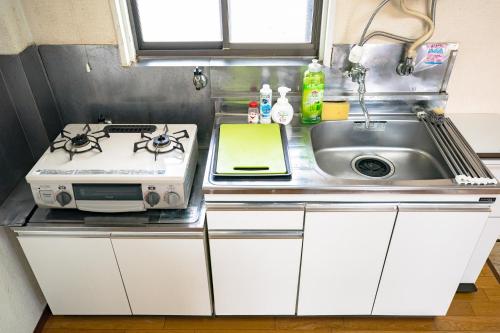 um balcão de cozinha com um fogão e um lavatório em Murata Corpo 301 em Tóquio